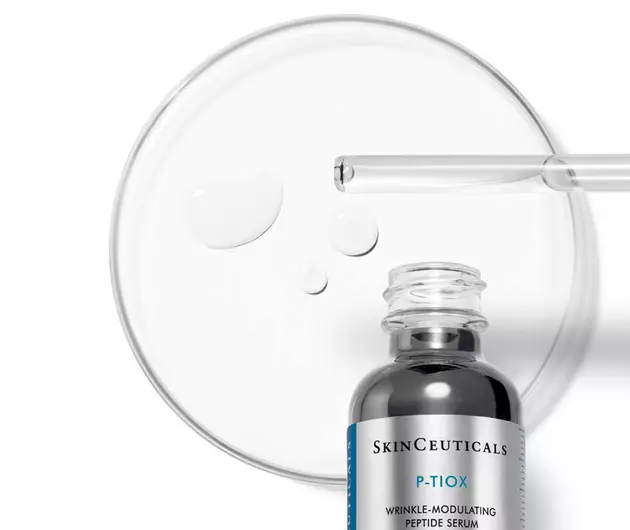 Ein Serumflaschchen von SkinCeuticals mit einer Pipette und Tropfen auf einer Petrischale.