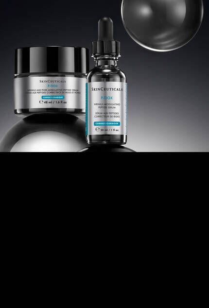 SkinCeuticals CE Ferulic Serum, A.G.E. Advanced Interrupter Creme und HA Intensifier Multi-Glycan Serum in einer Box mit Markenbandern vor dunklem Hintergrund.