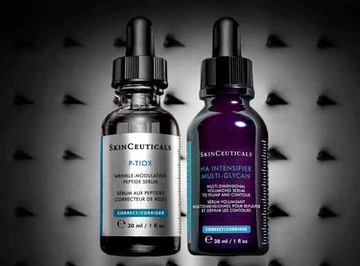 Zwei Flaschchen mit Pipetten, die Hautpflege-Seren zeigen, vor einem dunklen, strukturierten Hintergrund.