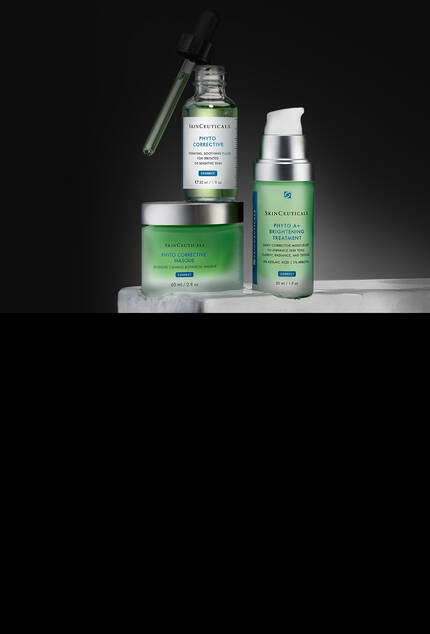 SkinCeuticals Phyto Corrective Serie. Drei Produkte sind ausgestellt: ein Serum mit Pipette, ein Gel in einer Pumpflasche und ein Tiegel mit Maske, alle auf einer Marmoroberflache