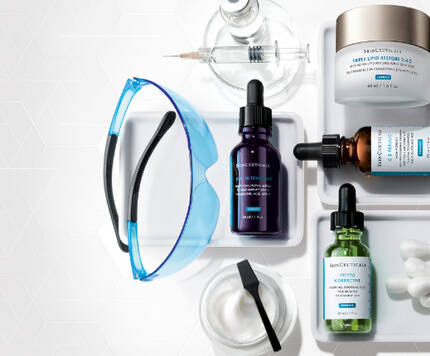 Alt-Text: Anordnung von Hautpflegeprodukten, einschließlich Seren, Cremes und Applikatoren, auf einem hellen Hintergrund.