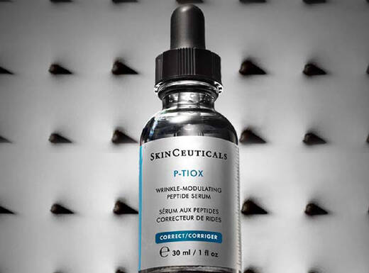 Serumflaschchen von SkinCeuticals mit Pipette vor einer hellen, strukturierten Hintergrund.