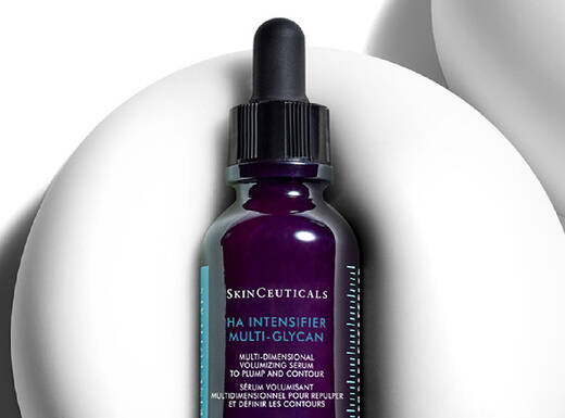 Ein Flaschchen mit Hautpflege-Serum von SkinCeuticals, das auf einem weißen, geschwungenen Hintergrund steht.