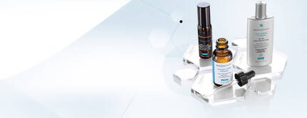 Drei Hautpflegeprodukte in einer transparenten Display-Prasentation auf hellem Hintergrund.