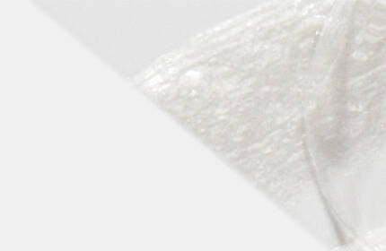A close-up of fluffy white texture with a soft, smooth appearance against a light background.