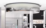 Ein moderner Empfangsbereich von SkinCeuticals mit elegantem Design und gut sichtbarem Logo im Vordergrund.