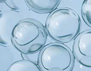 Durchsichtige, kugelformige Blasen auf blauen Hintergrund, die Licht reflektieren und fur einen transparenten Effekt sorgen.