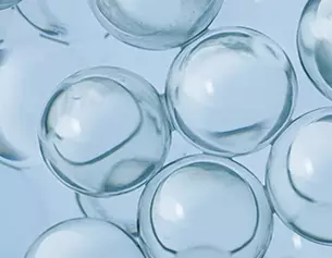 Durchsichtige, kugelformige Blasen auf blauen Hintergrund, die Licht reflektieren und fur einen transparenten Effekt sorgen.