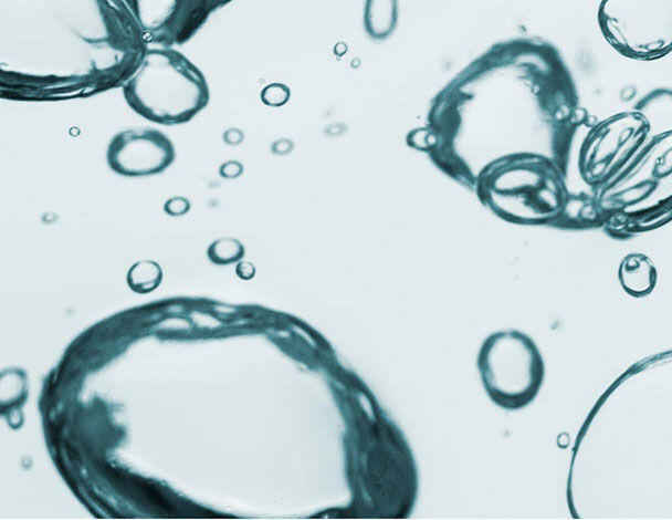 Schaumige Wasserblasen schweben im klaren Wasser, Licht reflektiert auf ihren Oberflachen.