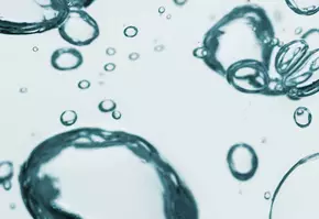 Schaumige Wasserblasen schweben im klaren Wasser, Licht reflektiert auf ihren Oberflachen.