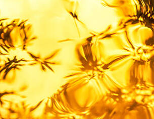 Goldene Wellen und verschwommene Konturen spiegeln sich in einem warmen, lichtdurchfluteten Hintergrund.