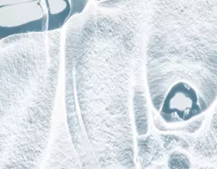 Abstract close-up of textured ice, showcasing intricate patterns and a frosty appearance.