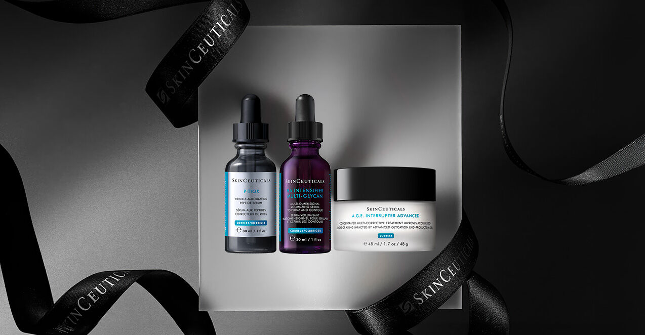 A minimalistic display featuring three skincare products from Skinceuticals: two dropper bottles and a cream jar, arranged on a reflective surface with black ribbons in the background.