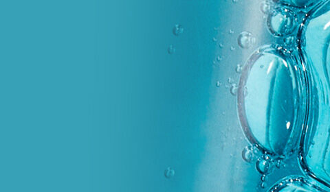 Abstract close-up of a clear, blue liquid with bubbles, set against a light background.