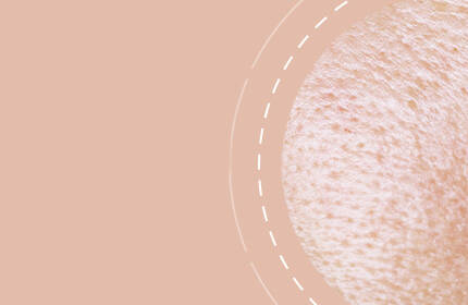 Close-up of skin texture with a soft, peach-colored background.