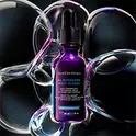 Eine Flasche SkinCeuticals H.A. Intensifier Serum, umgeben von perlmuttartigen, blasenartigen Effekten