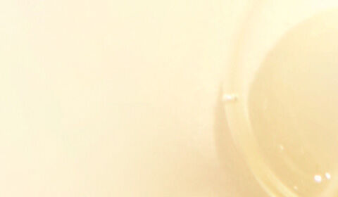 A close-up of transparent bubbles on a soft, light-colored background.