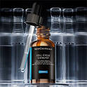 Im Fokus: die SkinCeuticals Cell Cycle Complex Serumflasche mit herausgezogenem Pipette, vor verschwommenen Flaschen im Hintergrund