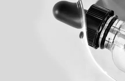 Close-up of a white device with a black knob and a clear glass component.