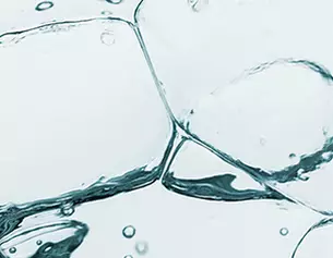 Wassertropfen und Blasen in einer transparenten Flussigkeit, die eine frische, klare Atmosphare vermittelt.