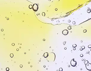 Bunte Blasen und Tropfen in gelb und transparent, die an Flussigkeiten in Bewegung erinnern.