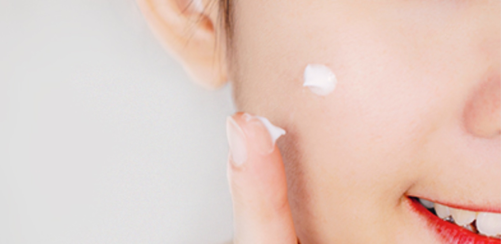 Finger und Wange von Frau mit einem Tropen Creme